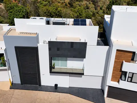 Casa con paneles solares y calentador solar en la azotea, sistema de respaldo de energía