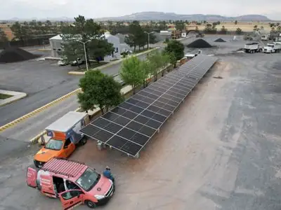 Paneles solares de Riotrack montados en suelo en un patio de maquinaria en Zacatecas, con camionetas de Active Energy